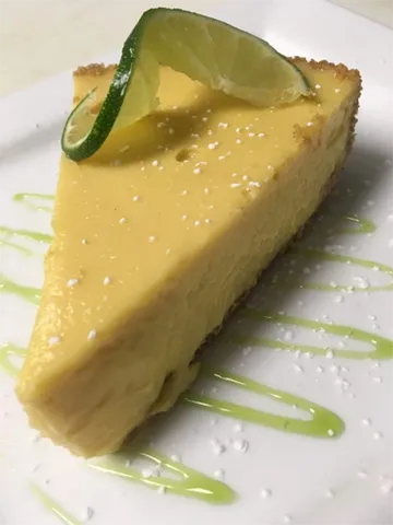 Slice of key lime pie garnished with a fresh lime wheel