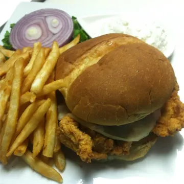 Crispy fried chicken sandwich with french fries and coleslaw