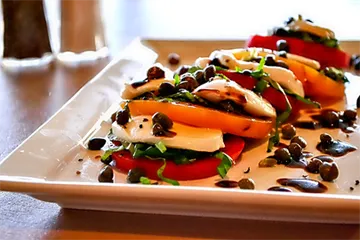 Caprese salad with tomato, mozzarella, basil, and a balsamic drizzle