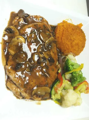 Grilled steak topped with mushroom sauce, served with sweet potato and mixed vegetables