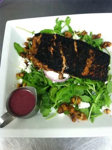 Blackened fish over an arugula salad with goat cheese and berry vinaigrette
