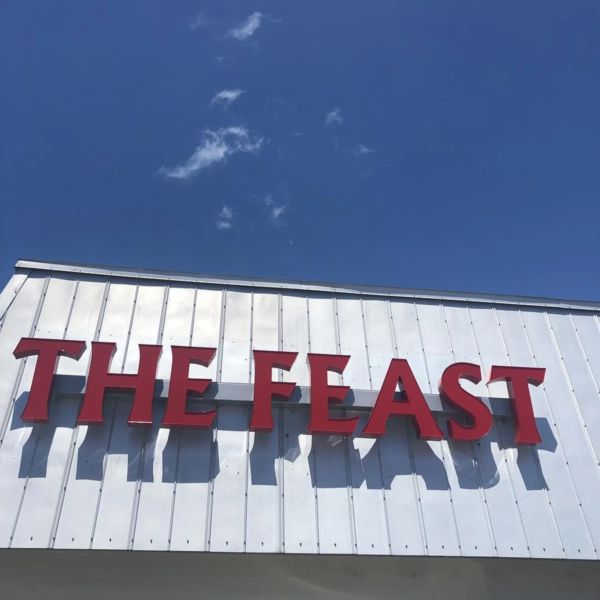 The Feast Restaurant sign on the building exterior in Holmes Beach, FL